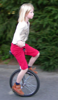 Mädchen fährt auf einem roten Einrad